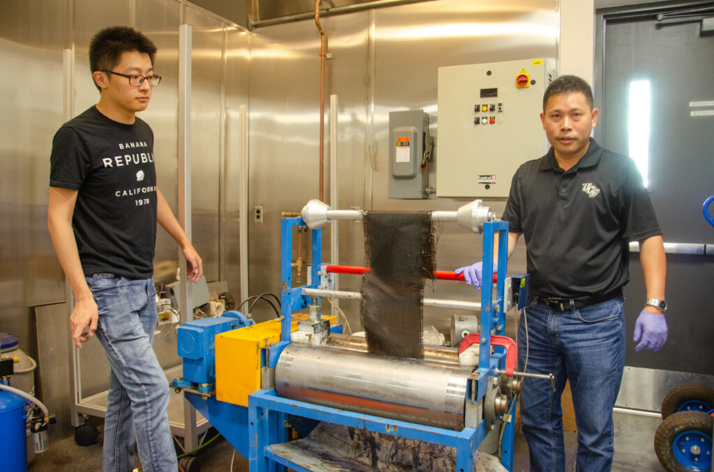Jan Gou poses in his lab with a student
